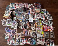 Top-down photo showing a large spread of hockey cards on a wooden floor, including various players and teams with colorful designs.