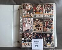Binder open showing Boston Bruins player cards in nine-pocket sheet