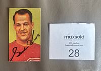 Front view of Gordie Howe signed card next to scale reference card