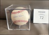 Baseball inside acrylic cube with visible Moises Alou signature and Maxsold lot card