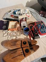 Overview photo displaying all 8 vintage miscellaneous items on a table, including wooden shoe stretchers, crystal prisms, multimeter, blue tin, and other pieces.