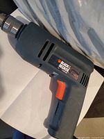 Side view of Black and Decker electric drill showing brand label and trigger.