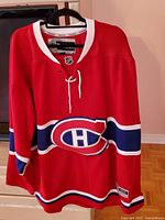 Front view of the red Montreal Canadiens hockey jersey showing logo placement and design.