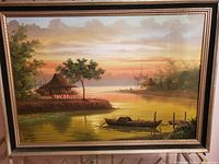 Full view of the vintage oil painting showing the sunset, bamboo boats, nipa huts, and surrounding trees, in a decorative frame.