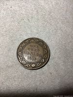 Reverse side of the 1918 Canadian large one cent coin showing the denomination with maple leaf wreath surrounding, and the date 1918 in the center.