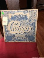 Front cover of vintage Chicago self-titled album, blue and white ornate design with band members' faces and 'Chicago' logo