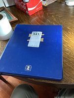 Blue binder with label showing lot number and '1' indication