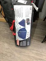 Front label on storage bag showing Coleman brand, tent depiction, and carrying handles