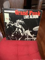 Front cover of the Grand Funk Live Album showing band performing with red and white text