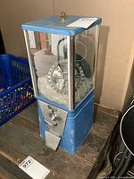 Full view of the vintage blue Astro gumball machine showing the glass panels and overall shape.