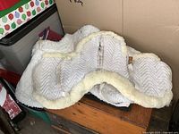 White fleece saddle pad with chevron quilted pattern and fleece trim shown from the top-down angle