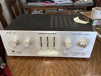 Full front view of Marantz PM 300 amplifier on wood table, showing control knobs, sliders and input options.