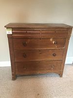 Front view of the antique pine dresser showing two small top drawers and three larger bottom drawers with wooden knobs, visible wear and scratches on drawer fronts.