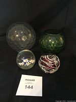 Overview photo showing all four items on a black background with a lot number card