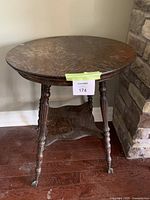 Full side view of antique entryway table showing claw ball feet, lower shelf, and leg detailing