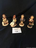 Four Hummel figurines displayed together showing general lot contents and size comparison; noted to be about five inches tall each.
