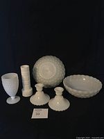 Collection displaying all items against a black background. Includes two bowls with bubble pattern, a goblet with bubble texture, two candle holders, and a vase.