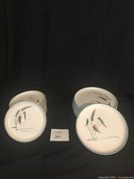 Set of 18 round ceramic plates in Greenwheat pattern arranged in two stacks: 8 luncheon plates and 10 dessert plates.