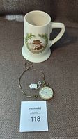 Photo of Royal Doulton stein featuring Winston Churchill with Montrose pocket watch and chain laid on brown fabric
