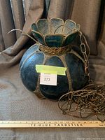 Full view of the hanging stained glass light showing dark blue rounded glass panels and attached chain.