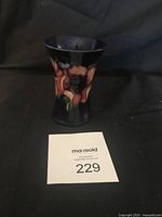 Front view of Moorcroft vase showing floral Anemone pattern in deep blue with pink flowers.