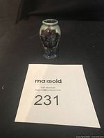 Miniature Moorcroft Anemone vase shown next to MaxSold number for scale.