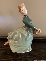 Side view of Royal Doulton Grace figurine showing flowing dress and fur muff