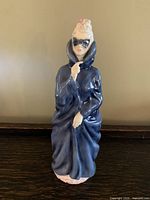 Front view of Royal Doulton Masque figurine showing full figure in blue cloak and mask.