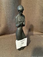 Front angle of black basalt Royal Doulton figurine showing overall shape, headwrap, and dress details.