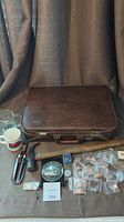 CN Rail vintage briefcase closed on table with mugs, tools, and medallion visible around it