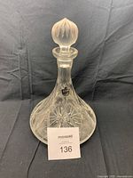 Full view of vintage clear lead crystal decanter with original sticker, showing pinwheel cut design and stopper in place.