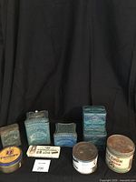 Photo of collection of vintage tobacco tins including Edgeworth, Old Chum, Troost, and Schimmelpenninck showing variety in size and condition on black backdrop.
