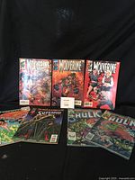 Photo showing all seven comics together: three Wolverine, two Superman, two Incredible Hulk.