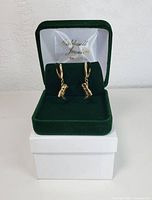 Pair of earrings displayed in green velvet Caldwell Jewellers box