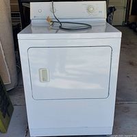 Front view of the white Maytag gas dryer showing the door with handle and power cord resting on top.