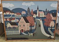 Full front view of the framed folk art canvas showing the entire village scene with houses, trees, road, figures, and church.