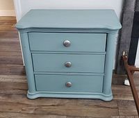 Front view of the Tiffany blue nightstand showing three drawers with round metal knobs, curved top edges and base molding.