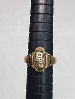Front view of the 1988 class ring showing the 'BE' initials with a green center stone and the year 1988 on the sides.