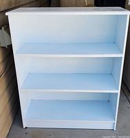 Front view of the light blue painted wooden 3 shelf bookcase showing all shelves and overall condition.