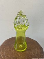 Front view of the chartreuse art glass flame sculpture showing the shape and color.