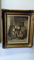 Gilt framed art print showing Victorian children in a domestic interior, clear detail on the frame and print.
