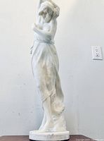 Front view of full height showing draped figure and base