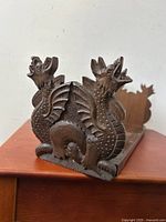 Close-up of carved dragon end showing detailed wings, claws, and face.