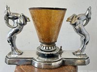 Front view of lamp unlit showing chrome base with twin ram figures and mica shade