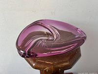 Triangular raspberry swirl glass bowl resting on wooden surface, top view showing swirl pattern.