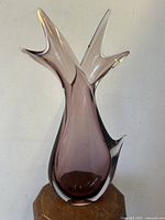 Front view of mauve glass vase with double fish tail design on top, showing shape and color