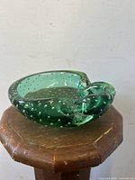 Side angle view of green Murano glass bowl showing controlled bubble design and smooth rounded edges.