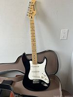 Full view of the $ Sound Nashville black and white six-string electric guitar with maple neck and fingerboard.