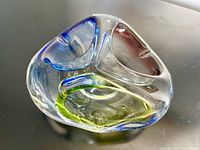 Clear vintage Czech art glass bowl with three internal color sections (blue, red, yellow-green). Shown on a surface for size context.