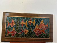 Full front view of vintage enameled metal angel fish wall art in wooden frame showing vibrant colors and mosaic style with fish.